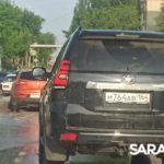 В Солнечном после дождя машины форсируют залитую водой дорогу